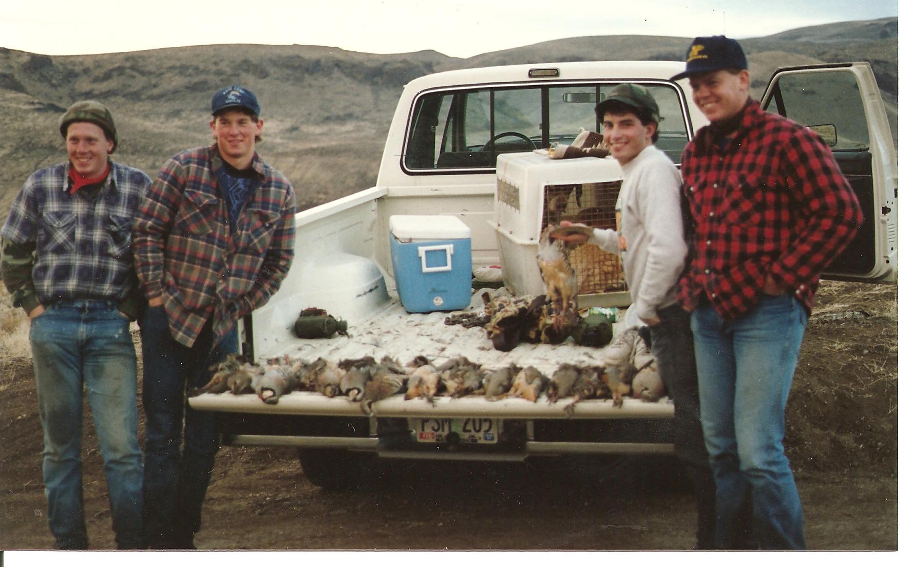 Teenagers gathered around a tailgate with their field dressed Chukars