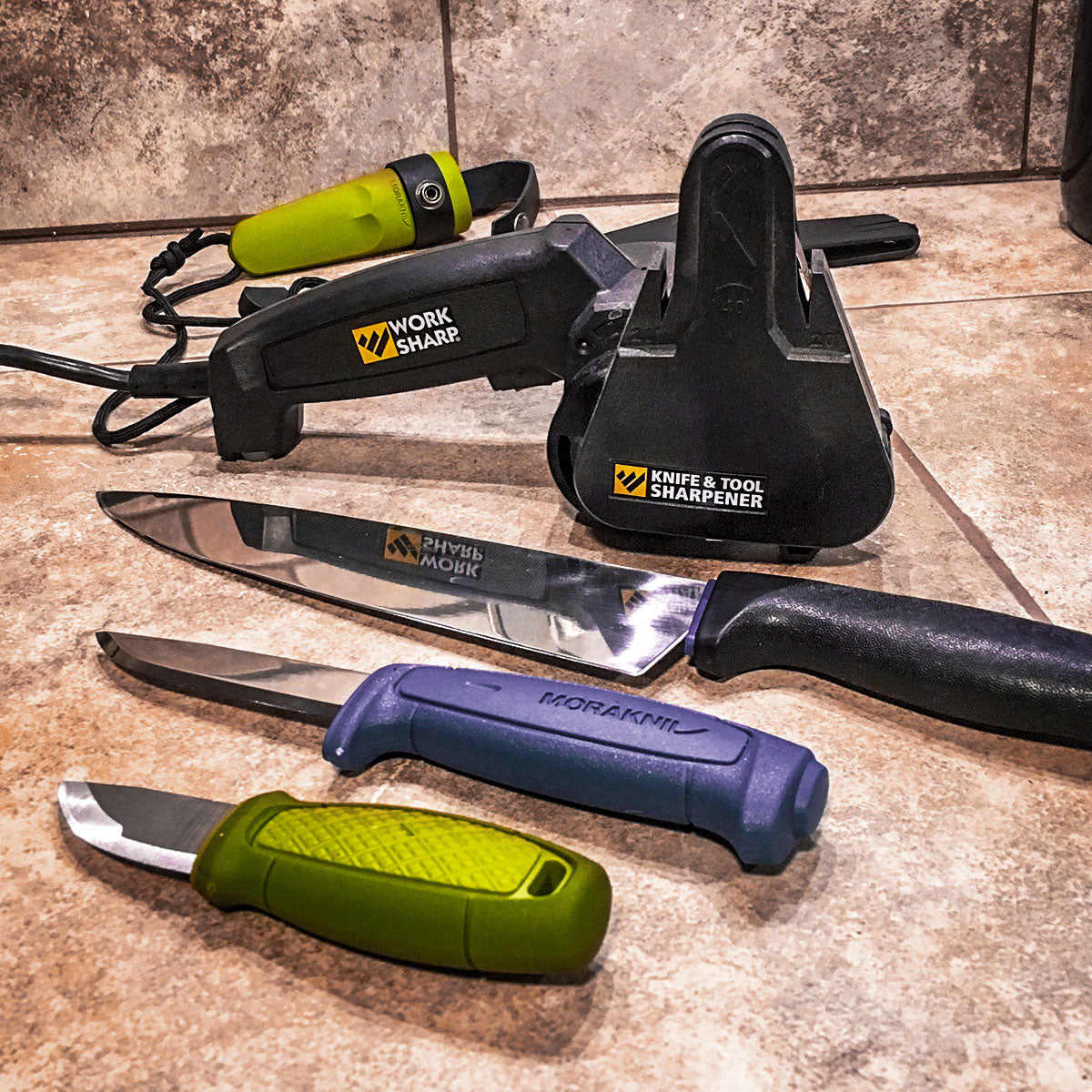 Work Sharp Knife and Tool Sharpener surrounded by knives