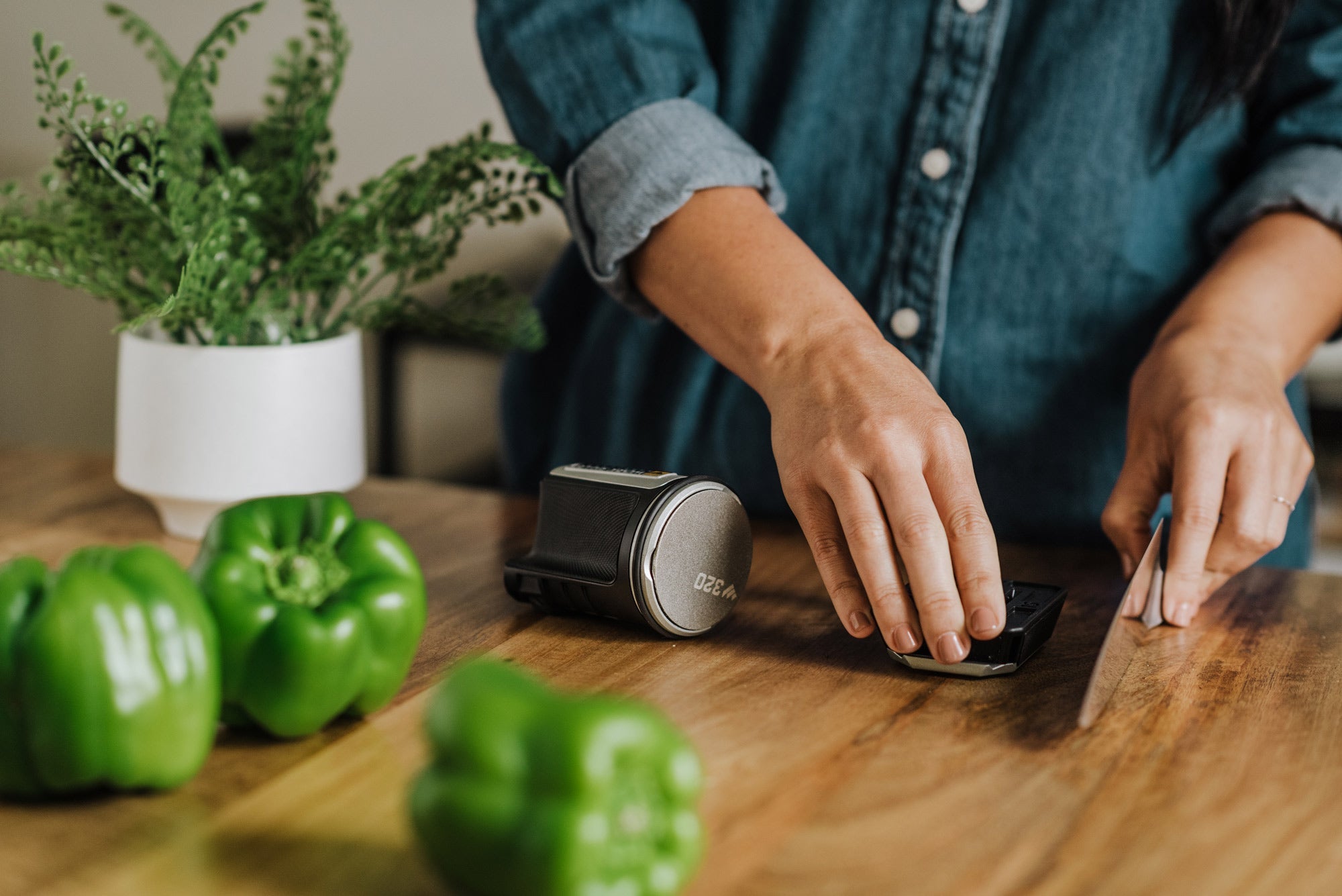 Rolling knife sharpener in kitchen surrounded by bell peppers